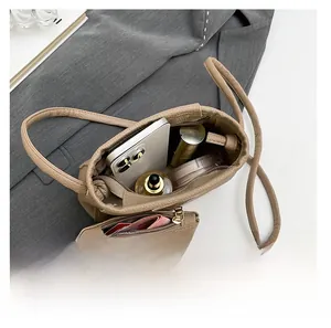 Vue intérieure du sac seau en cuir kaki montrant le grand espace et la petite pochette