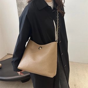 Sac fourre-tout chic en cuir croco kaki avec bandoulière chaîne dorée sur mannequin