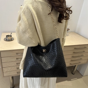 Sac fourre-tout noir à texture tressée avec chaîne dorée et fermoir métallique