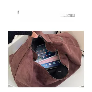 Interior view of brown suede tote bag showing large capacity with tablet and notebooks