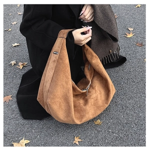 Detail of vintage brown suede hobo tote bag with a metallic zipper and shoulder strap