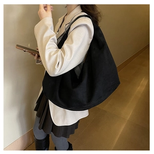 Side view of large black suede tote bag styled as a minimalist shoulder bag for women