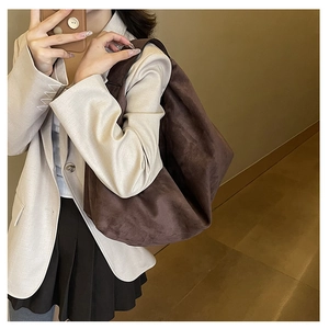 Close-up of dark brown suede tote bag showing soft texture and slouchy hobo silhouette
