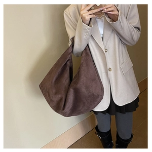 Detail of a large brown suede tote bag showing soft texture and spacious hobo style design