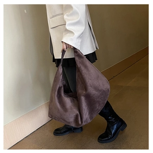 Close-up of dark brown suede hobo tote bag on model for a trendy commuter look