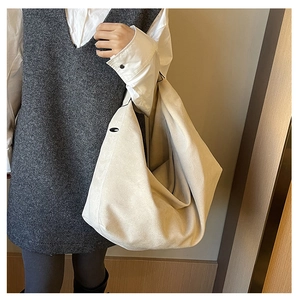 Close-up of beige suede hobo tote bag featuring a snap button and textured finish