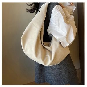 Detailed side view of off-white oversized pleated hobo tote bag on shoulder