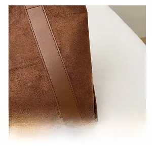 Detail view of tight stitching and high-quality suede material on the brown tote bag