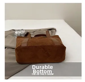 Detail view of the brown suede bucket bag featuring a reinforced wear-resistant bottom