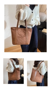 Detail view of large brown suede tote bag with leather straps and outer pocket