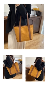Detail view of mustard yellow suede tote bag with brown leather straps and outer pocket