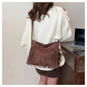Detail of dark brown frosted suede fringe bag with bohemian retro tassels style