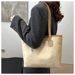 Detail of beige faux suede tote bag with slim shoulder strap and Gloryness text