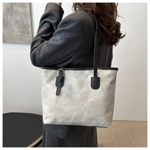Silver grey tote bag with marble texture, black leather straps and gold hardware detail