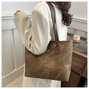 Detailed view of brown canvas tote bag with vintage texture and long shoulder strap