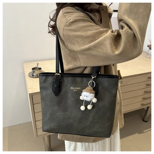 Detail of large olive grey tote bag with TidalDryness branding and plush charm