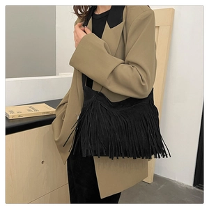 Dettaglio borsa a tracolla nera con frange in finta pelle scamosciata stile boho