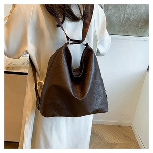 Detailed view of large dark brown tote bag worn over shoulder with premium PU texture