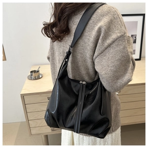 Detailed view of black soft leather hobo bag with dual decorative long zipper straps