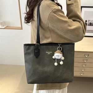 Large dark green faux leather tote bag for women with plush charm and adjustable strap