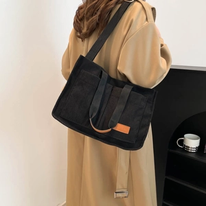 Minimalist large black corduroy tote bag for women featuring two pockets and long strap