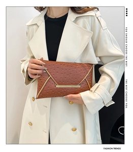 Close-up of brown ostrich texture envelope clutch bag with gold metallic trim accents