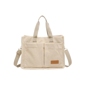 Large beige corduroy tote bag with dual front pockets and adjustable shoulder strap
