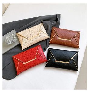 Detailed close-up of textured ostrich pattern envelope clutches in four classic colors