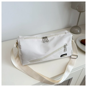 Détail du sac bandoulière en nylon blanc crème avec fermetures éclair et logo mode