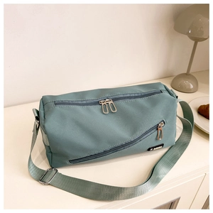 Détail du sac bandoulière en nylon vert Morandi avec double fermeture éclair et sangle