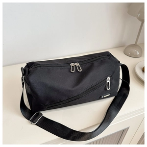 Détail du sac bandoulière en nylon noir étanche avec fermetures éclair et logo