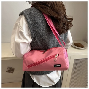 Détail de la sacoche rose avec fermeture éclair diagonale et sangle réglable au dos
