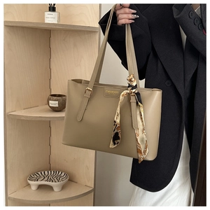 Détail du sac cabas kaki en similicuir avec foulard en soie et logo en métal doré