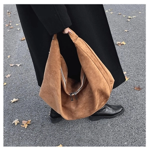 Detail of caramel suede tote bag featuring a double zipper closure and matte texture