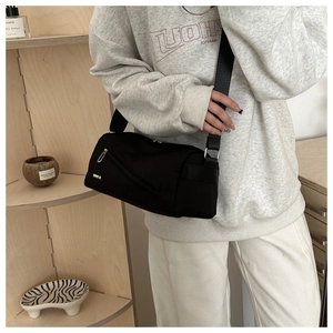 Vue détaillée du sac bandoulière en nylon noir avec fermeture éclair argentée