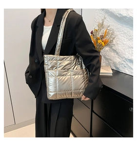 Detail of champagne gold quilted puffer tote bag with metallic finish and shoulder strap