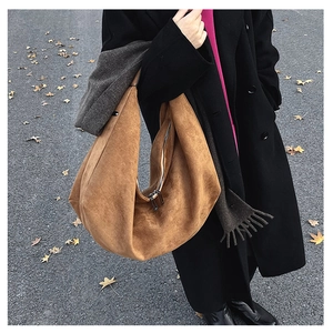 Street view of a large brown suede hobo bag with zipper showing soft texture and autumn vibes