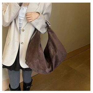 Detailed texture of large brown suede hobo bag worn with a casual chic beige blazer