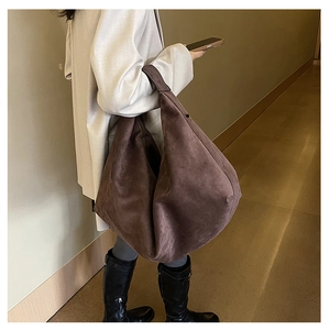 Detail of dark brown suede hobo bag showing spacious design and soft leather texture