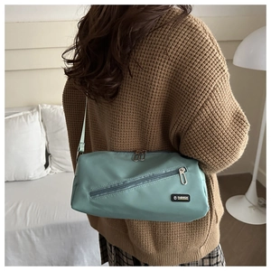 Détail du sac bandoulière en nylon vert menthe avec zip diagonal et sangle réglable