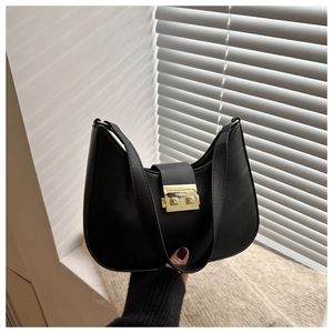 Close-up of black crescent shoulder bag featuring a sleek golden rectangular metal buckle