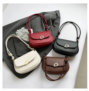 Detailed close-up of retro saddle bags in four colors with gold metal buckles and knotted straps