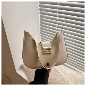 Detail of beige crescent bag featuring a matte leather finish and golden metal buckle