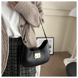 Close-up of black leather hobo bag featuring a sleek golden metal clasp for women