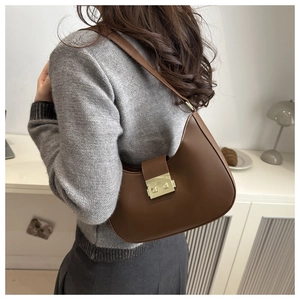 Close-up of a brown crescent hobo bag featuring a vintage golden square metal buckle