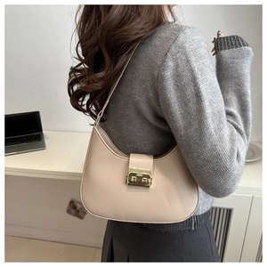 Detail of beige crescent hobo bag with gold metal square clasp and matte leather texture