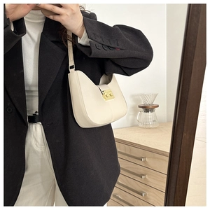 Chic cream half-moon underarm bag with gold metal buckle shown in a lifestyle mirror selfie