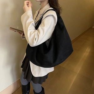 Large black suede hobo shoulder bag styled with a beige blazer for a minimalist look