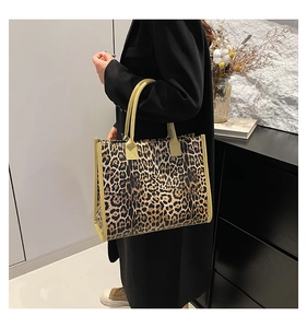 Side view of leopard print tote bag with yellow handles on a stylish model in suit