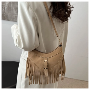 Detail of camel suede fringe shoulder bag with long tassels and metallic buckle